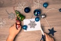 Christmas background with the hands of a child preparing New Year`s decorations on a wooden table. View from above Royalty Free Stock Photo