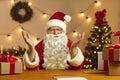 Happy Santa Claus talking on video call with kids using webcam on laptop. Christmas background. Royalty Free Stock Photo