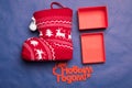 Christmas background with the inscription in Russian New Year`s studio image. Red gift box with christmas sock on a blue backgroun