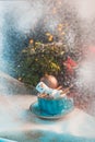 Christmas background with a marshmallow man lying in a mug with cocoa, in the background a Christmas tree with toys, a garland and Royalty Free Stock Photo