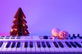 Christmas background with midi keyboard and holiday decor with neon lights.