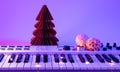 Christmas background with midi keyboard and holiday decor with neon lights.