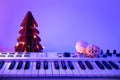 Christmas background with midi keyboard and holiday decor with neon lights.