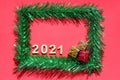 Christmas background with 2021 new year`s number. Christmas frame made of green tinsel on a red background. Empty space for text Royalty Free Stock Photo