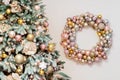 Christmas background, New Year\'s wreath of sparkling balls in delicate pink colors, and decorated Christmas tree in defocus. Royalty Free Stock Photo