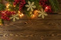 Christmas background. Nobilis fir branches, twigs with red berries, toy golden snowflakes on brown wooden planks. Copy space, flat Royalty Free Stock Photo