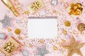 Christmas background with notebook, gift or present box, champagne, confetti and decorations on pink table top view. Flat lay. Royalty Free Stock Photo