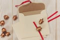 Christmas background.Open envelope with golden acorns.White wooden table.Empty space
