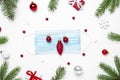 Christmas background during pandemic of Covid 19 made from face mask, fir tree and decorations. top view Royalty Free Stock Photo