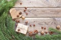 Christmas background with pine branches, gift box, nuts, cinnamon sticks and star anise in an old wooden table. Space for text. Royalty Free Stock Photo