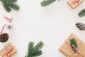 Christmas background with pine cones, fir branches and gifts over wooden white background. Flat lay, top view.