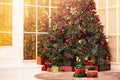 Christmas background pine tree branch with decorations red balls gifts and star, with sun light Royalty Free Stock Photo