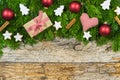 Christmas present with decorations on rustic wood background and green fir branches border Royalty Free Stock Photo