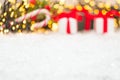 Christmas background with presents, gist boxes with red ribbon, candy stick and Christmas tree and bokeh of golden lights with
