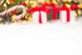 Christmas background with presents, gist boxes with red ribbon, candy stick and Christmas tree and bokeh of golden