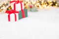 Christmas background with presents, gist boxes with red ribbon, Christmas tree and bokeh of golden lights with copy