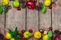 Christmas Background Background with Red Apples Citrus Cones Candy Canes and Red Christmass Balls on Old Wooden Backgroun Holidays