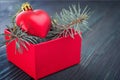 Christmas background: red gift box with a Christmas toy in the form of a heart and fir branches Royalty Free Stock Photo