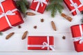 Christmas background with red gift boxes, fir tree branches, pine cones, cinnamon sticks and stars anise. Red Christmas gift box. Royalty Free Stock Photo