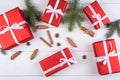 Christmas background with red gift boxes, fir tree branches, pine cones, cinnamon sticks and stars anise. Red Christmas gift box. Royalty Free Stock Photo