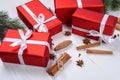 Christmas background with red gift boxes, fir tree branches, pine cones, cinnamon sticks and stars anise. Red Christmas gift box. Royalty Free Stock Photo