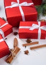 Christmas background with red gift boxes, fir tree branches, pine cones, cinnamon sticks and stars anise. Red Christmas gift box. Royalty Free Stock Photo