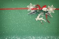 Christmas background with red silk traditional ribbon, white deer, evergreen tree, paper snowflakes and jingle bells. Royalty Free Stock Photo