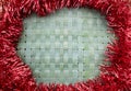 Christmas background: red tinsel with woven New Zealand flax mat
