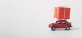 Christmas background with red toy car Volkswagen Beetle and big gift box on white