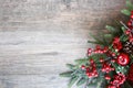 Christmas Background with Rustic Evergreen Pine Tree Branches and Red Berries Over Wood Table Royalty Free Stock Photo