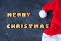 Christmas background with Santa's cap and baked gingerbread words merry christmas . creative idea