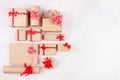 Christmas background - set of various craft paper gifts with red ribbons and bows on soft light white wood board, flat lay. Royalty Free Stock Photo