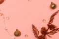 shiny golden balls, beads, cones and branches on a pink background - flat lay. Copy space center Royalty Free Stock Photo
