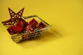 Creative Christmas background with shopping basket with Christmas gifts on a yellow background Royalty Free Stock Photo