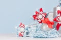 Christmas background - silver glittering ball with red silk bow closeup, blur and decorations on soft light blue color backdrop. Royalty Free Stock Photo