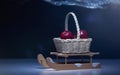 Christmas background with sled, basket with red apples, light effects, dark background Royalty Free Stock Photo