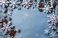 Christmas background with snowflakes and cones on light blue slate texture. Top view, copy space. Winter flatlay Royalty Free Stock Photo