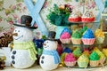 Christmas background with snowman, Christmas tree and cupcakes on wooden table, copy space. Festive snowmen.