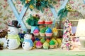 Christmas background with snowman, decorated Christmas tree and colorful cupcakes on wooden table, copy space. Festive snowmen.