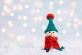 Christmas background with a snowman in a green hat and a red scarf. Greeting card with a happy toy snowman. Happy New Year. Space Royalty Free Stock Photo