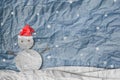 Christmas Background, Snowman wearing red Santa hat in winter with snow, paper cut made of crumpled paper