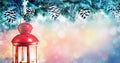 Christmas background with snowy fir branches illuminated with lantern