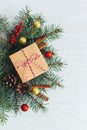 Christmas background with spruce branches, red berries, cones, cinnamon sticks and gift box. Holiday concept. White wooden Royalty Free Stock Photo