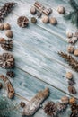 Christmas background. Spruce and pine branches on a light vintage wooden background of boards. Cones nuts spices in the decor. Royalty Free Stock Photo