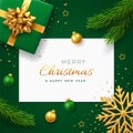 Christmas background with square paper banner, realistic green gift box with golden bow, pine branches, gold stars and glitter Royalty Free Stock Photo