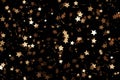 Abstract starry background with golden particles isolated on black