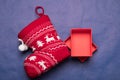 Christmas background studio image. Red gift box with christmas sock on a blue background.