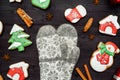 Christmas background with tasty homemade gingerbread cookies and knitted mittens on wooden table, top view, flat lay. Royalty Free Stock Photo