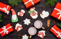 Christmas background with tasty homemade gingerbread cookies, two cups of hot cocoa and red gift boxes on wooden table, top view. Royalty Free Stock Photo