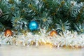 Christmas background with Christmas tree branches, blue and yellow layers and silver tinsel on a wooden background. Copy space for Royalty Free Stock Photo
